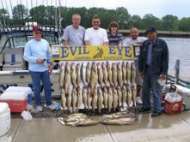 Six clients are proud to pose with a board full of great fish.