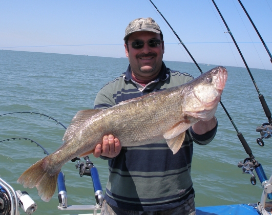 Customer holds up trophy walleye with outstretched hands.