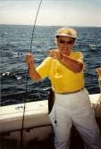 Woman holds up a Lake Erie Perch with a big smile on her face.