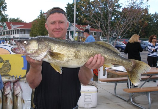 Customer holds up trophy walleye with outstretched hands.